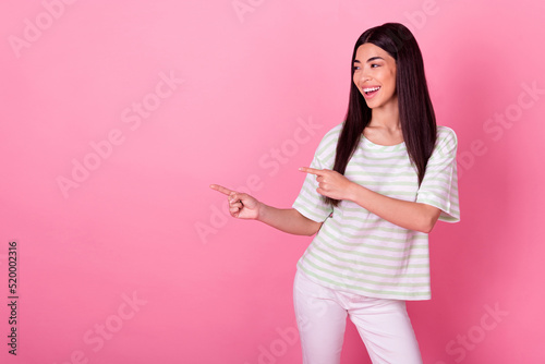 Portrait of gorgeous cheerful lady look indicate fingers empty space proposition isolated on pink color background