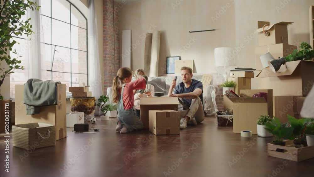 Happy Homeowners Moving In: Lovely Couple Sitting on the Floor of Cozy Apartment Unpacking Cardboard Boxes, Little Daughter Joins them. Cheerful Day, Happiness, Sweet Home for Young Family Having Fun