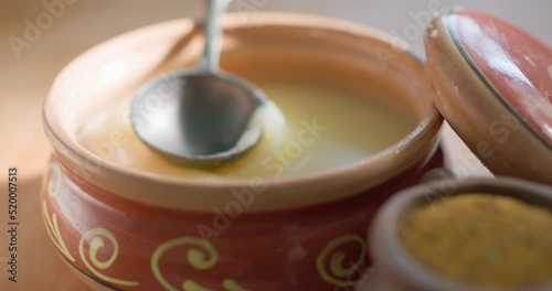 .Pure OR Desi Ghee also known as clarified liquid butter. Pure OR Desi Ghee in ceramic bowls on an old wooden table.