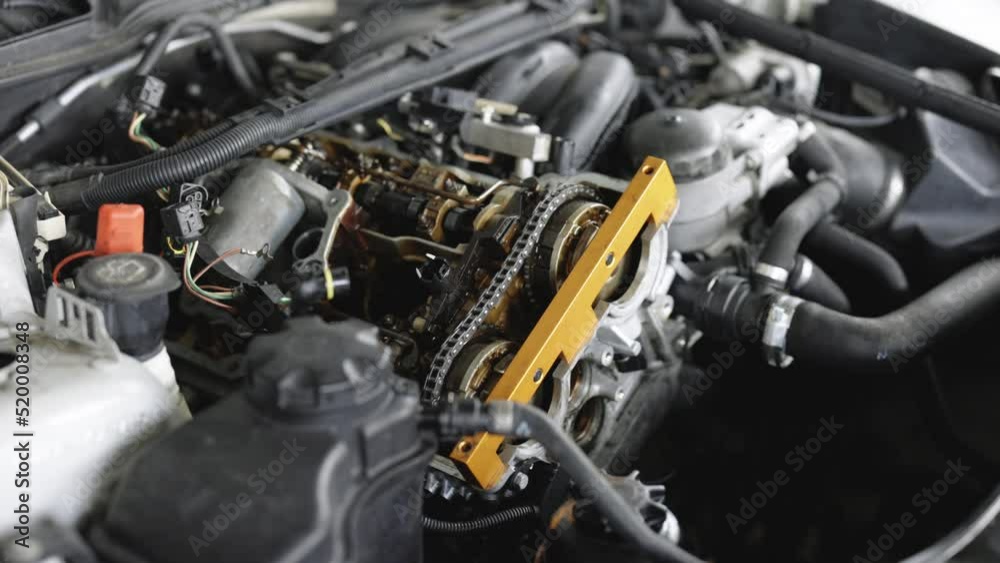 Disassembled motorcycle engine. Professional mechanic repairing motor using tool. Car mechanic repair the engine. Repairer working in garage or workshop. Man engaged servicing cars or motorbikes