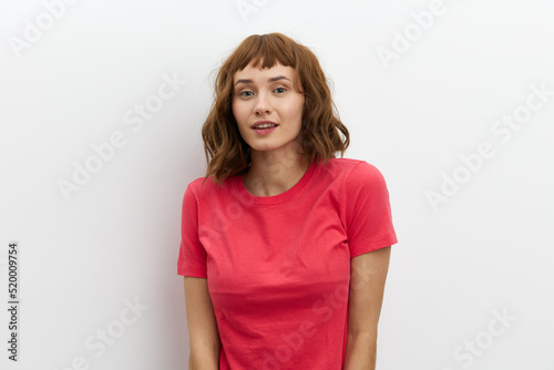 horizontal photo of a sweet, shy, pleasant woman standing on a white background with an empty space for inserting an advertising layout
