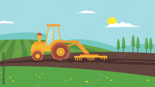 yellow tractor plows in the field