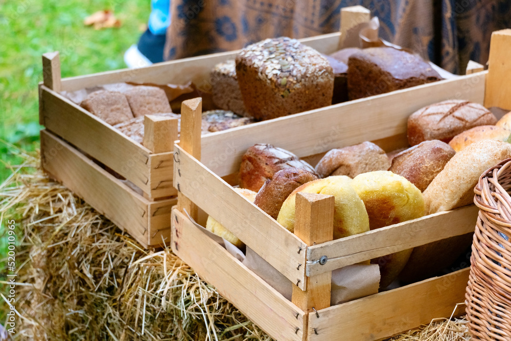 Fresh organic bread in wooden boxes on street farmer market.