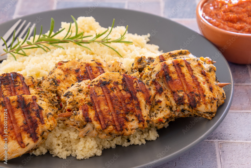 brochettes de poulet grillées et couscous dans une assiette brochettes de poulet grillées et couscous dans une assiette