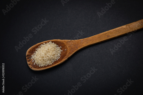 wooden spoon with salt and spices on a dark background 