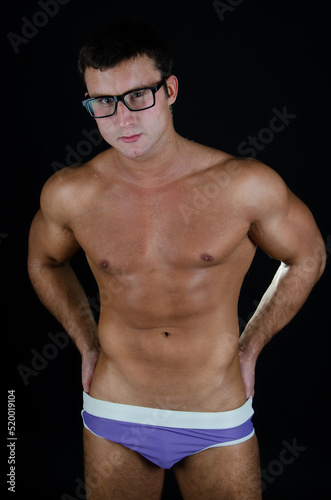 Young handsome man with athletic body posing in the studio. Sports and healthy lifestyle.  © vladorlov