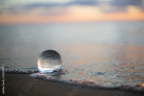 夕暮れの砂浜と水晶玉