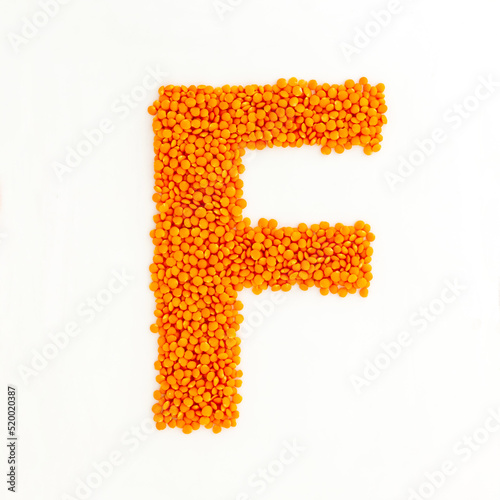 Capital letter F made from red lentils. Lentil font. White background. Bright font for menu or food blog. Lettering design element. Init cap