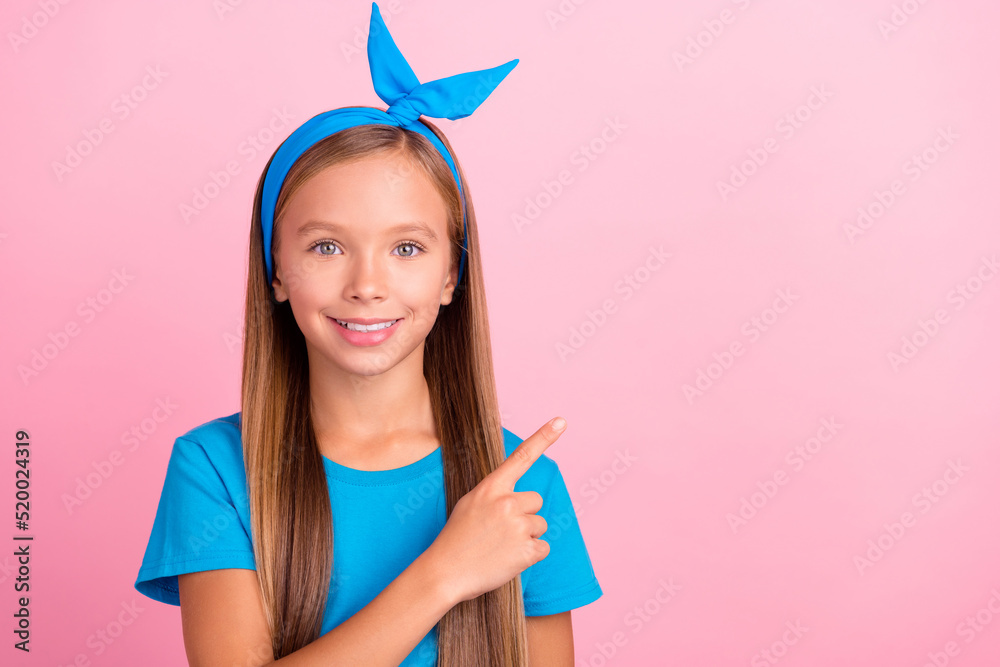 Photo of cheerful nice girl toothy smile indicate finger empty space offer isolated on pink color background Photo of cheerful nice girl toothy smile indicate finger empty space offer isolated on pink color background