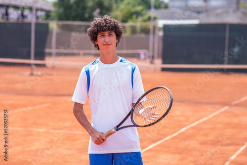 Young man tennis player with racket standing on tennis court © spoialabrothers