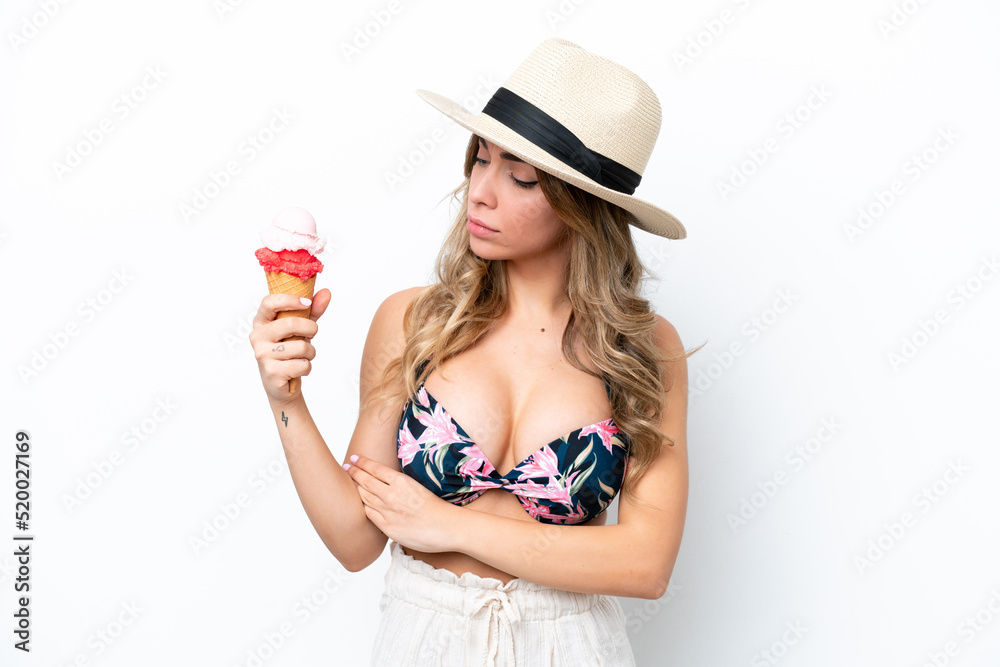 Girl wearing a swimsuit and holding cornet ice cream isolated on white background with sad expression Girl wearing a swimsuit and holding cornet ice cream isolated on white background with sad expression
