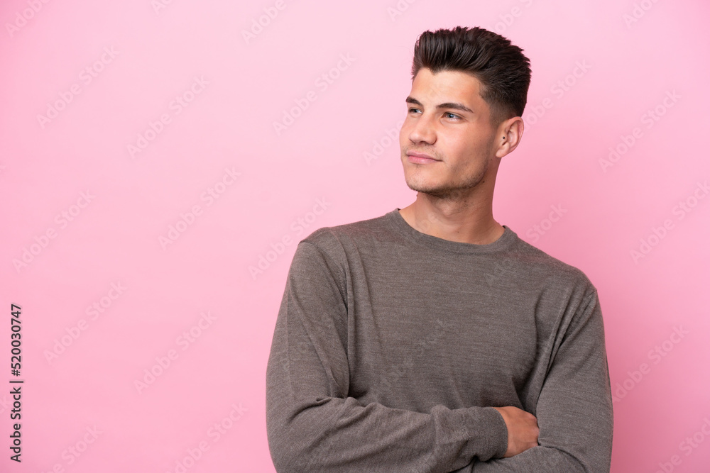 Young caucasian man isolated on pink background looking to the side Young caucasian man isolated on pink background looking to the side
