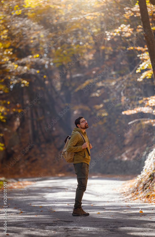 Young handsome man posing in autumn forest.