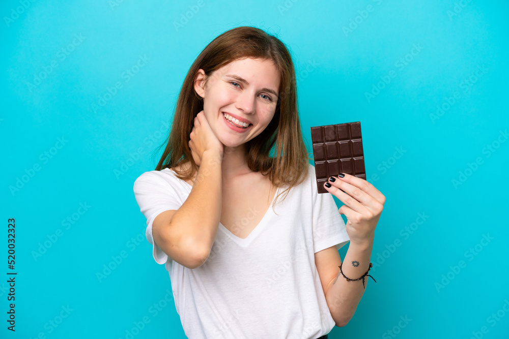 Young English woman with chocolat isolated on blue background laughing Young English woman with chocolat isolated on blue background laughing