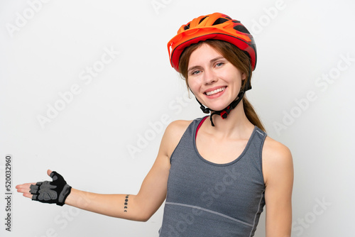 Young cyclist English woman isolated on white background extending hands to the side for inviting to come © luismolinero