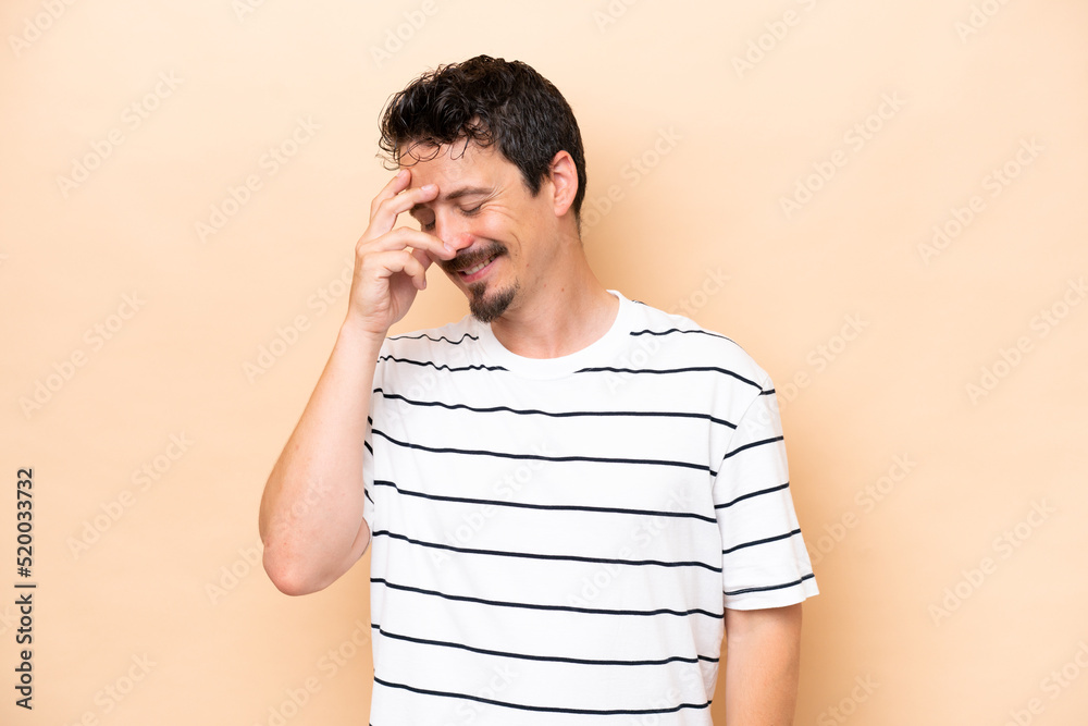 Young caucasian man isolated on beige background laughing Young caucasian man isolated on beige background laughing