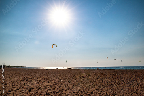 Windy west coast of Rhodes island with paraglides on sea photo