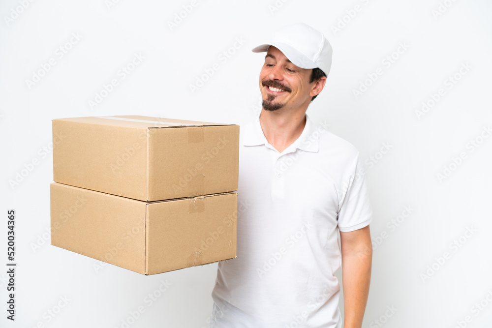 Delivery caucasian man isolated on white background looking to the side and smiling Delivery caucasian man isolated on white background looking to the side and smiling