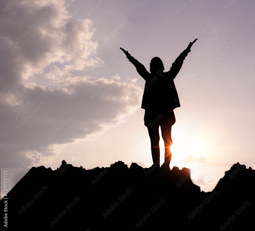 Silhouette of a woman praying over a beautiful sky. Hypnosis concept.