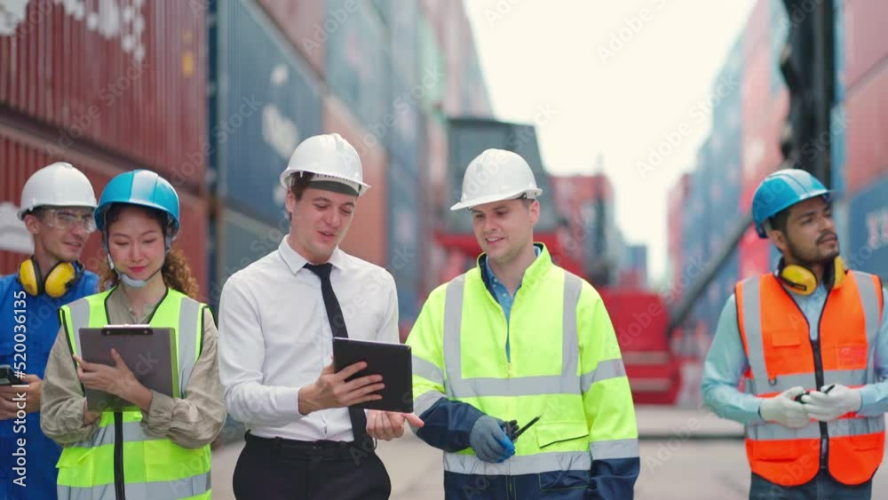 Group of engineer worker and manager standing in the shipping yard container. Truck lifting and forklift behind. Import, export product. Manufacturing transport and global business concept Group of engineer worker and manager standing in the shipping yard container. Truck lifting and forklift behind. Import, export product. Manufacturing transport and global business concept