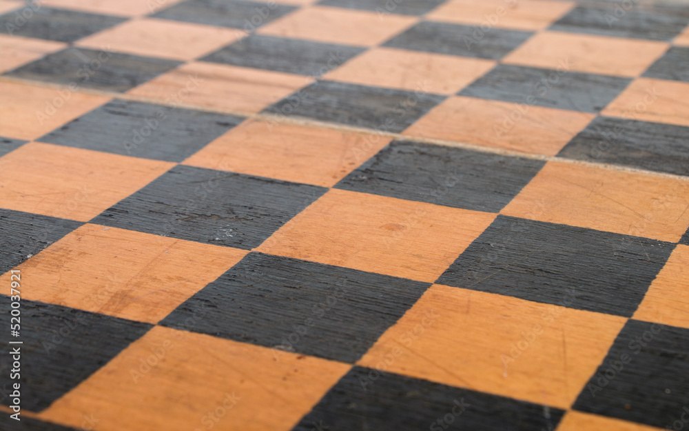 Fototapeta premium shabby surface of an old wooden chessboard, close-up