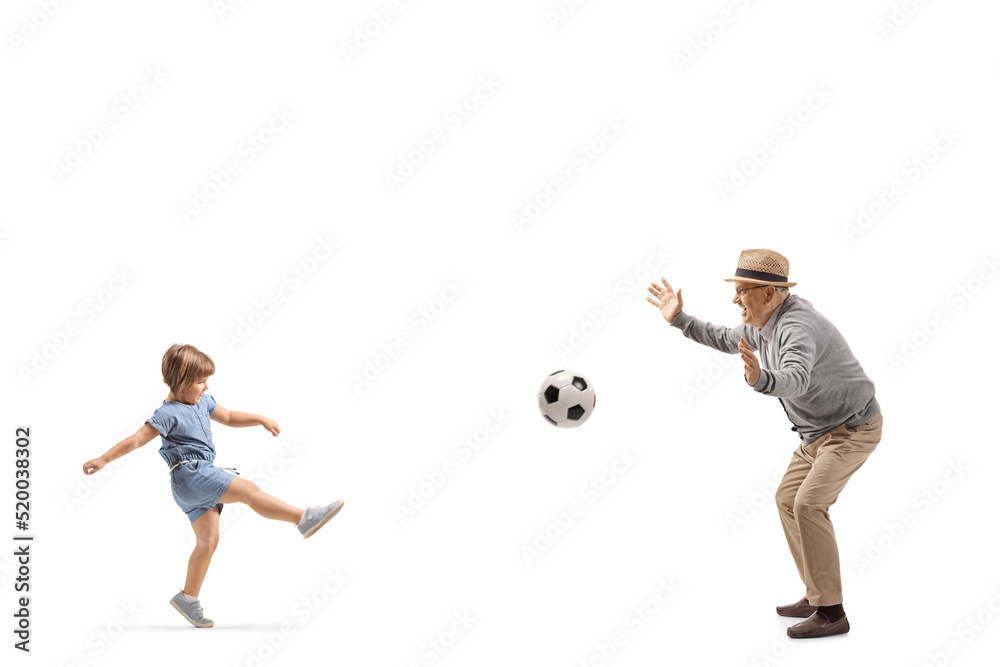 Full length profile shot of a little girl playing football with a senior man