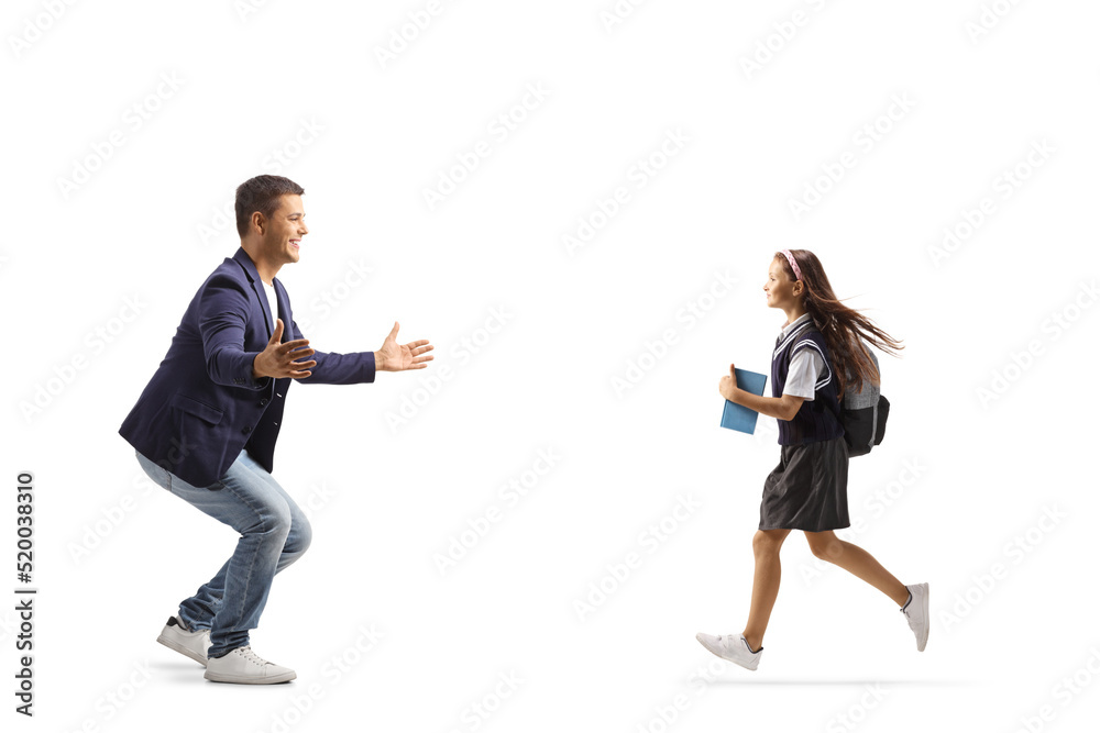 Full length profile shot of a schoolgirl running to hug her happy father