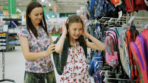 Mom tries on a new school backpack for her daughter before the new school year.
