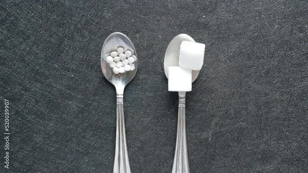 comparing artificial sweetener container and sugar cube on spoon 