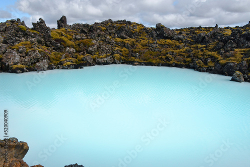 Blue Lagoon hot spring with volcanic black rocks and moss in the south of Iceland