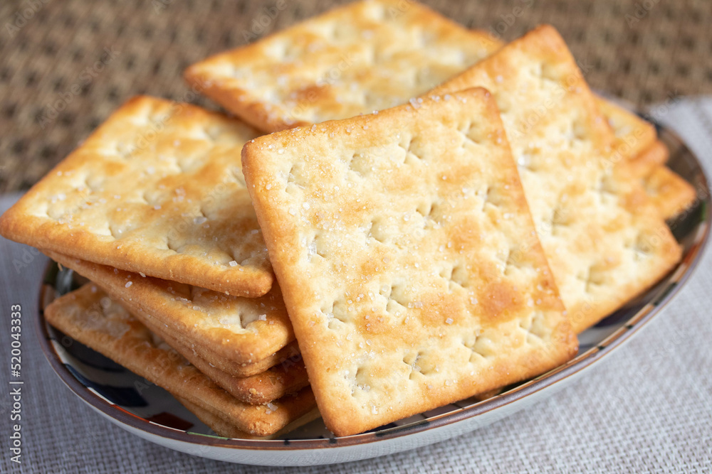 A pile of dry, thin crackers in a cup. Natural light. A pile of dry, thin crackers in a cup. Natural light.