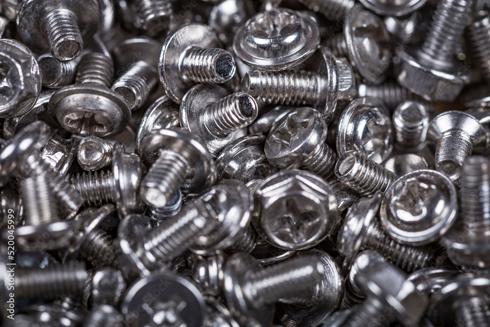 Close up of chrome machine screws on the counter of a hardware store. Background of the screws. Close up of chrome machine screws on the counter of a hardware store. Background of the screws.