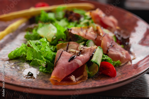 Vegetables and prosciutto crudo salad.Restaurant meat fresh salad close up. Mediterranean seasonal side dish.