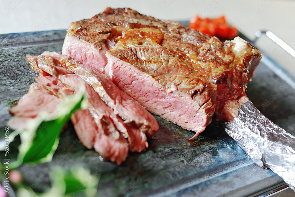 Fototapeta premium Ribeye steak on the bone sliced on stone
