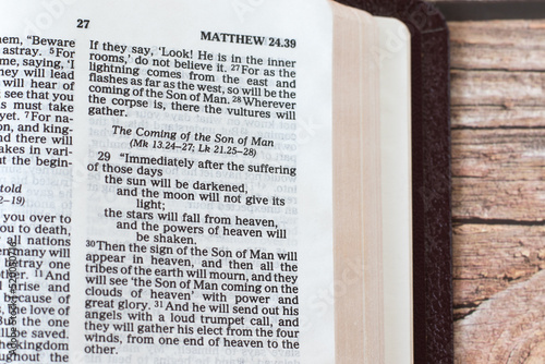 Coming of the Son of Man sign, biblical verses in an open Holy Bible Book on a wooden table. A closeup. Matthew 24 end time prophecy. Christian biblical concept.