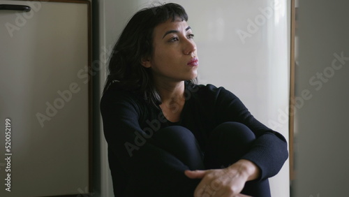 Photos One anxious hispanic latina woman sitting on floor overwhelmed by problems