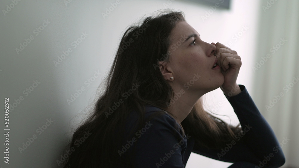 Nervous woman suffering from depression sitting on floor. Frustrated person in mental anguish feeling regret Nervous woman suffering from depression sitting on floor. Frustrated person in mental anguish feeling regret