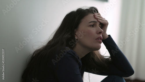 Nervous woman suffering from depression sitting on floor. Frustrated person in mental anguish feeling regret photo
