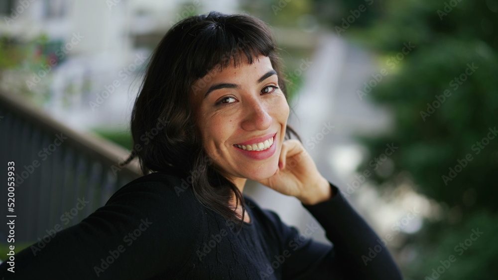 Portrait of a young hispanic Brazilian woman face looking at camera. Latin girl standing at balcony apartment smiling - obrazy, fototapety, plakaty 