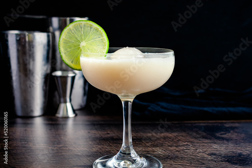 White Chocolate Gimlet Gin Cocktail with Ice Sphere: Cocktail made with gin, lime cordial, and white chocolate liquer in a coupe glass