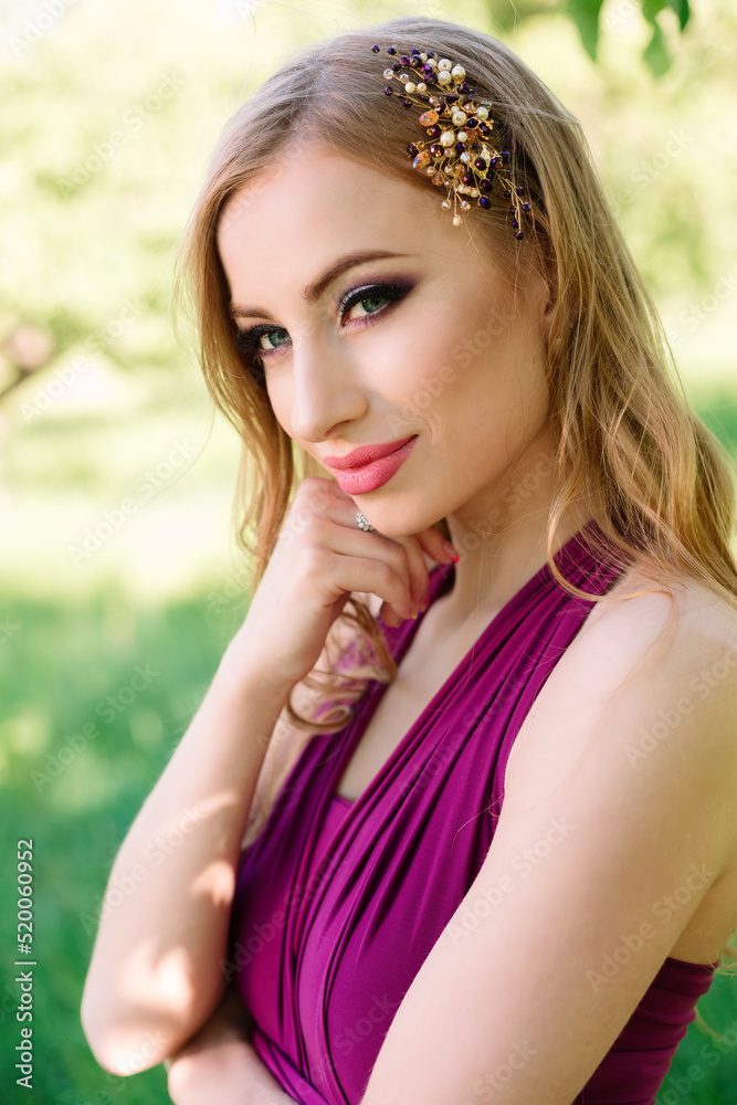 Beauty close-up shot of a young beautiful girl model in a purple dress with a tiara wedding decoration on her hair. Professional makeup and styling. High quality photo.