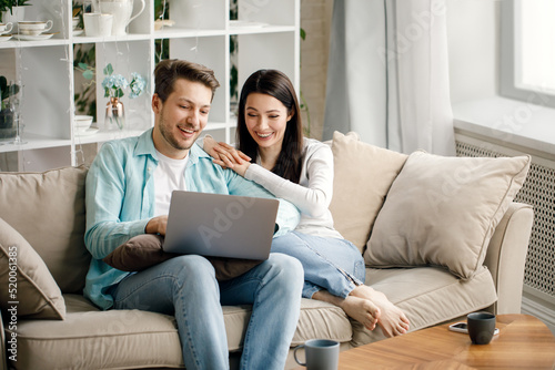 Schilderij op canvas Young couple enjoy Social teleconferencing with their family via laptop screen i