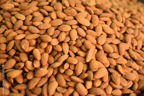 Background of big raw almonds street view, selective focus