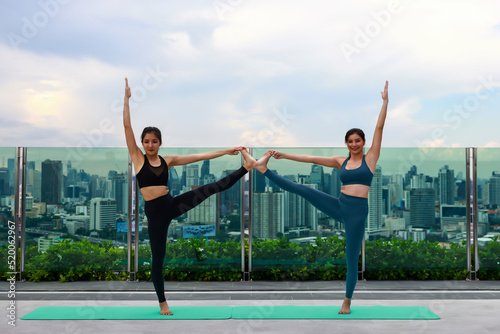 Healthy women with sportswear exercise yoga at rooftop garden of resident condominium, Urban people lifestyle after work