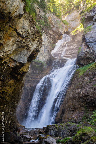 Impresionante cascada cayendo por un barranco rodeado de paredes verticales