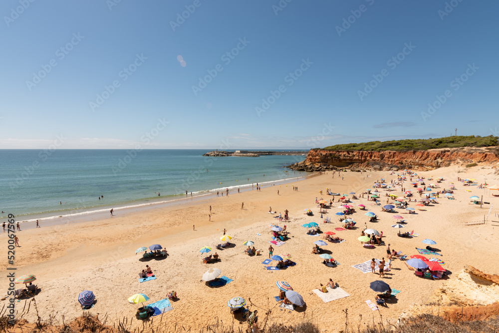 beach of the coast of southern Spain in summer. image of a sandy beach full of tourists with towels and umbrellas to protect themselves from the sun. vacation and relaxation concept in summer