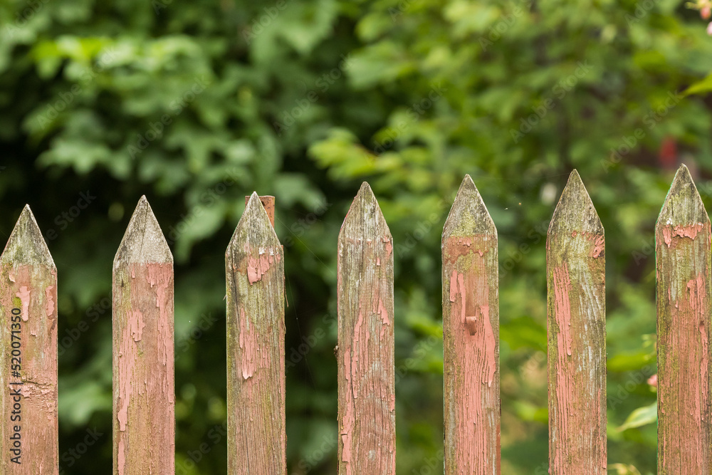 Old wooden fence with peeling red