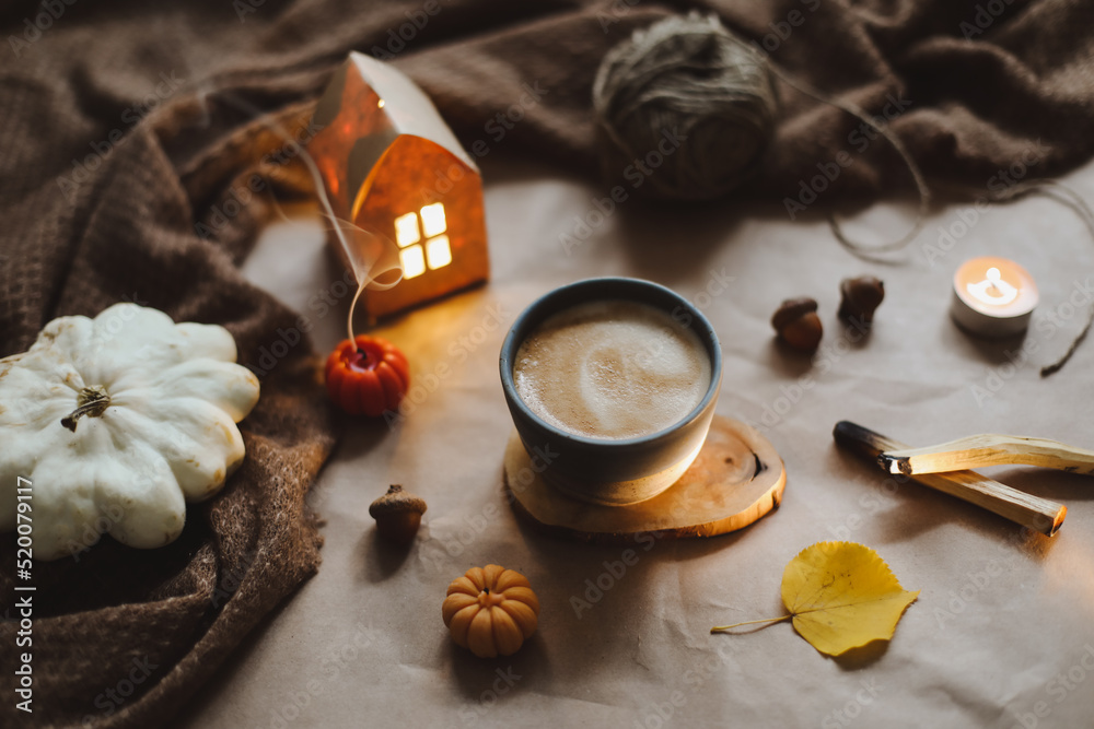 Autumn still life with a cup, candles, plaid. Hygge, Halloween and Thanksgiving concept Autumn still life with a cup, candles, plaid. Hygge, Halloween and Thanksgiving concept