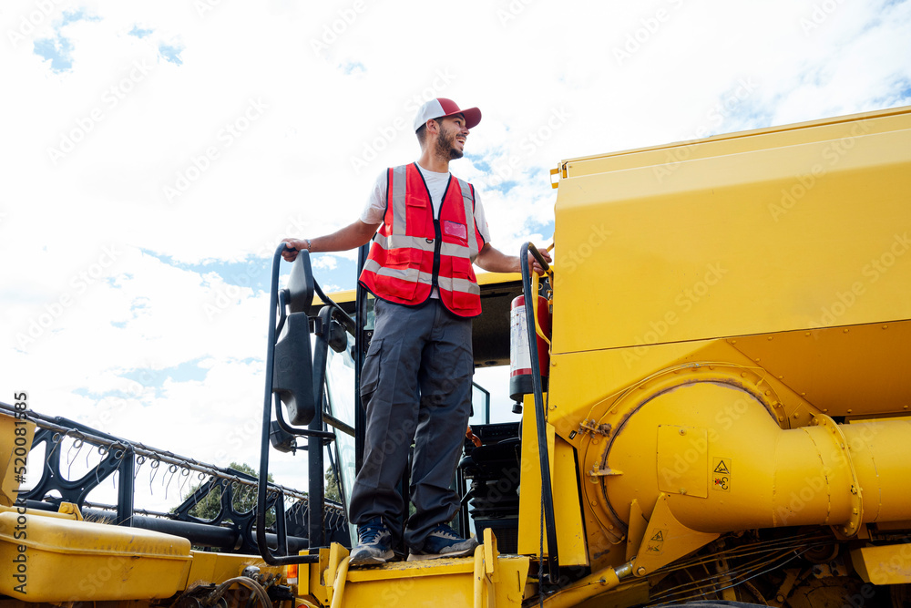 © ADDICTIVE STOCK - Man standing on ladder of combine harvester © ADDICTIVE STOCK - Man standing on ladder of combine harvester