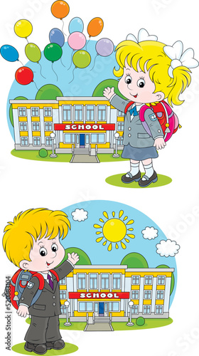Happy little schoolchildren with schoolbags and their school on a sunny day